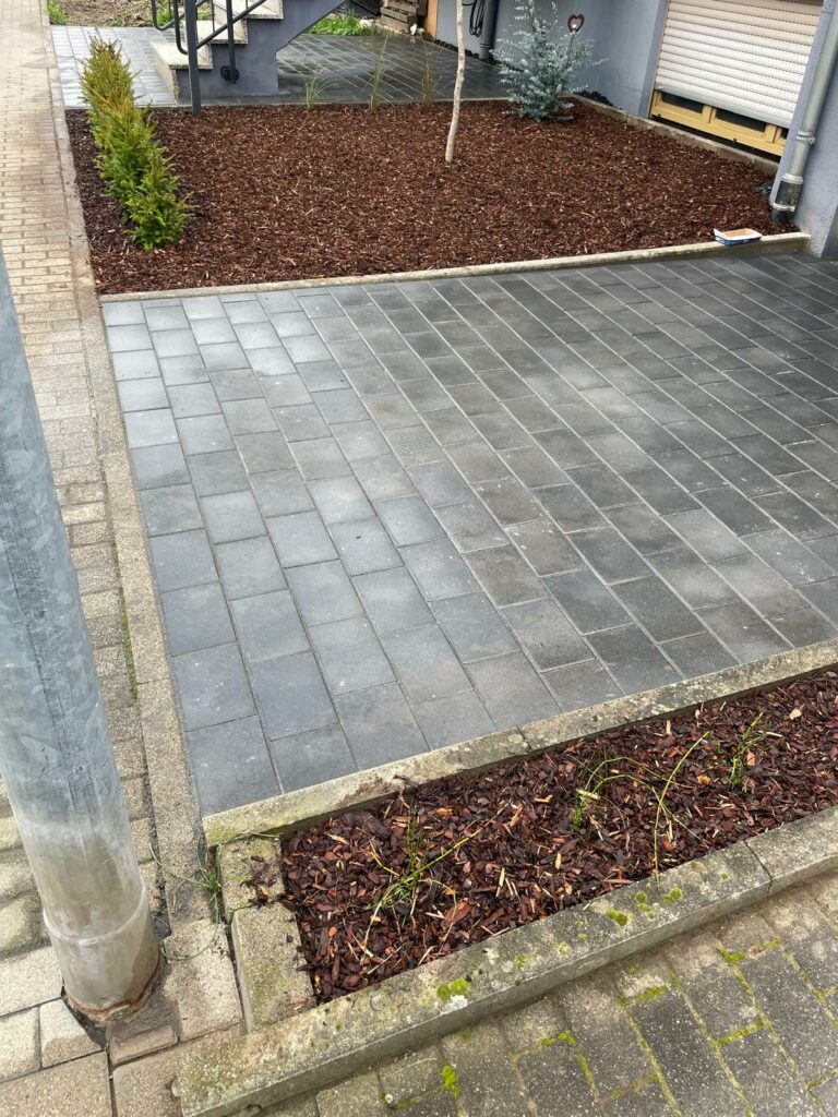 Gepflasterter Hof, Beete mit Rindenmulch.